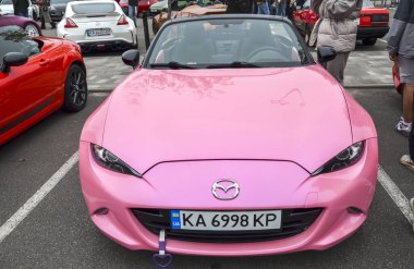 Canlı pembe Mazda MX-5 üstü açık Japon spor arabası mükemmel dengesi, zamansız stili ve heyecan verici açık-top sürüş deneyimiyle bilinir.