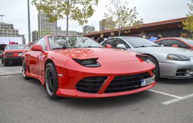 Çarpıcı kırmızı Mitsubishi 3000GT efsanevi Japon spor arabası. Farı farı, faşist heykeli ve düşük profilli duruşu var. Hız ve güç yayıyor.