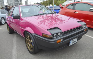Pembe 1984 model Toyota Trueno AE86 Coupe dışarıda park edilmiş. İkonik JDM klasiği. Sürüklenme ve araba kültürüyle ünlüdür. Otomotiv, akort ve klasik araba temaları için ideal