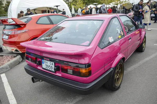 Pembe 1984 model Toyota Trueno AE86 Coupe dışarıda park edilmiş. İkonik JDM klasiği. Sürüklenme ve araba kültürüyle ünlüdür. Otomotiv, akort ve klasik araba temaları için ideal