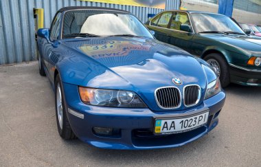 Üstü açık mavi BMW Z3, açık havada park edilmiş şık tasarımlı klasik bir roadster. Otomotiv, lüks araba ve klasik araç temaları için mükemmel.