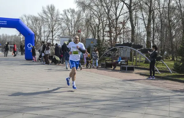 Bir maratonu tamamlayan kararlı bir sporcu, açık gökyüzünün altındaki bir açık hava etkinliğine katılıyor.