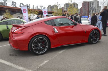 Red Nissan 370Z Nismo açık hava etkinliğinde. Özel tekerli şık spor araba, otomotiv meraklıları ve galeriler için ideal.
