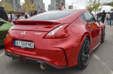 Red Nissan 370Z Nismo açık hava etkinliğinde. Özel tekerli şık spor araba, otomotiv meraklıları ve galeriler için ideal.