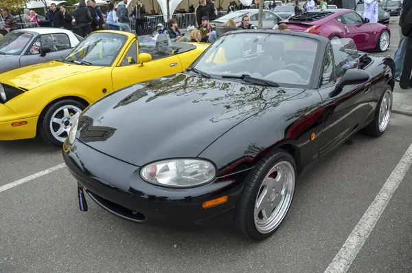 Siyah Mazda MX-5 Miata üstü açık araba fuarında gösterişli tasarımını sergiliyor. Otomotiv özellikleri, klasik araba galerileri veya etkinlik promosyonları için mükemmel.