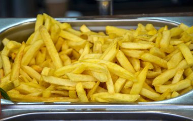 Metalik bir tepside ayarlanmış çıtır patates kızartması. Hızlı atıştırmak için mükemmel. Fast food yemekleri ya da günlük yemek için ideal taze patates tabağı.