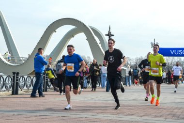 Bir maratonda koşan sporcular özel bir köprünün kaldırımlı yolunda koşuyorlar