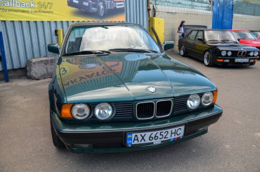 Koyu yeşil 1992 BMW E34 açık havada park edilmiş. Klasik tasarım, temiz kaporta ve kendine özgü BMW tasarımı.