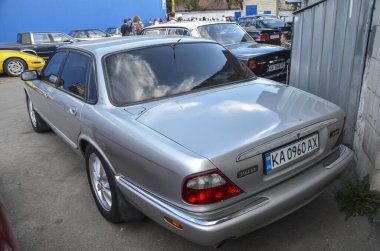 Klasik Jaguar XJ (X308) gümüş renginde, açık havada park edilmiş. Zarif kıvrımlı, krom aksanlı ve zamansız rafine edilmiş ikonik İngiliz lüks sedanı.