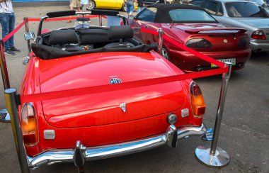 Üstü açılabilen 1970 model parlak kırmızı MG MGB 'nin ön görüntüsü. Klasik araba şovları ve İngiliz otomotiv tarihi için mükemmel.