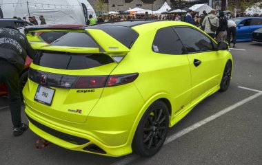 Parlak yeşil Honda Civic R Tipi (FN2) özelleştirilmiş ön tampon, siyah tekerlekler ve özel ışıklandırma ile açık hava otomotiv etkinliğinde sergilenmektedir.