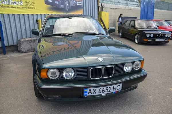 Koyu yeşil 1992 BMW E34 açık havada park edilmiş. Klasik tasarım, temiz kaporta ve kendine özgü BMW tasarımı.