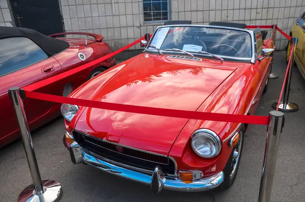 Üstü açılabilen 1970 model parlak kırmızı MG MGB 'nin ön görüntüsü. Klasik araba şovları ve İngiliz otomotiv tarihi için mükemmel.