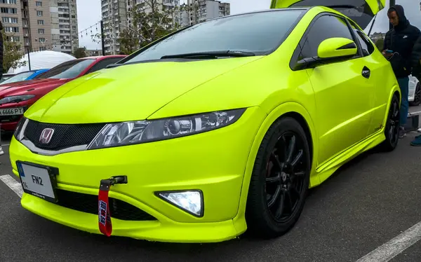 Parlak yeşil Honda Civic R Tipi (FN2) özelleştirilmiş ön tampon, siyah tekerlekler ve özel ışıklandırma ile açık hava otomotiv etkinliğinde sergilenmektedir.