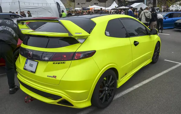 Parlak yeşil Honda Civic R Tipi (FN2) özelleştirilmiş ön tampon, siyah tekerlekler ve özel ışıklandırma ile açık hava otomotiv etkinliğinde sergilenmektedir.