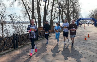 Koşucular açık hava maratonunda ağaçların arasındaki manzaralı patikadan geçerek yarışıyorlar. Motivasyon etkinliği kararlılık, uygunluk ve takım çalışmasını betimliyor