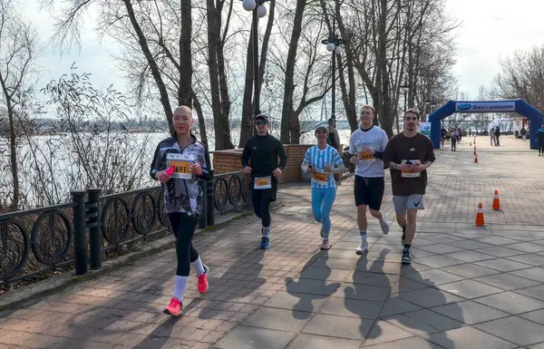 Koşucular açık hava maratonunda ağaçların arasındaki manzaralı patikadan geçerek yarışıyorlar. Motivasyon etkinliği kararlılık, uygunluk ve takım çalışmasını betimliyor