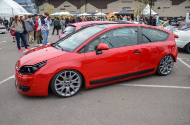 Modifiye edilmiş parlak kırmızı Citroen C4 hatchback son derece indirgenmiş süspansiyonu, siyah çatısı ve benzersiz koyu renk farıyla öne çıkıyor.