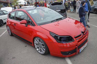 Modifiye edilmiş parlak kırmızı Citroen C4 hatchback son derece indirgenmiş süspansiyonu, siyah çatısı ve benzersiz koyu renk farıyla öne çıkıyor.