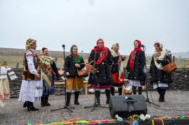 Canlı, geleneksel Ukrayna halk kostümlü, nakışlı detaylar ve eşarplı kadınlar Shrovetide kutlamaları sırasında açık havada hafif karda sepet tutarak gösteri yapıyorlar.
