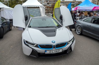 Çarpıcı beyaz BMW i8 hibrid spor yara, fütüristik ve aerodinamik tasarım ile ikonik kelebek kapıları dramatik bir şekilde açık BMW i-serisi karakteristiği