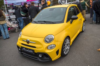 Çarpıcı, parlak sarı Fiat 500 Abarth, agresif vücut kiti elementleri ile kompakt yüksek performanslı hatchback ve krom çevrili dairesel farlar