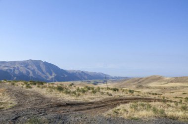Yuvarlanan kurak tepeler ve yumuşak bulutlarla dolu engin bir açık gökyüzü. Doğal huzurun, uzak güzelliğin ve bozulmamış arazilerin büyüklüğünün mükemmel bir temsili. Ermenistan