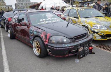 Son derece kişiselleştirilmiş, kestane rengi ve siyah Honda Civic hatchback, büyük arka spoyler, pazardan sonra çok dilli tekerlekler ve düşük süspansiyon, performans