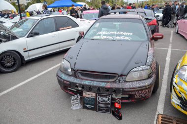 Son derece kişiselleştirilmiş, kestane rengi ve siyah Honda Civic hatchback, büyük arka spoyler, pazardan sonra çok dilli tekerlekler ve düşük süspansiyon, performans