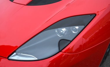 Şık, modern far ve parlak kırmızı renkli spor Lotus arabası aerodinamik tasarımı ve parlak bitişiyle sergileniyor.