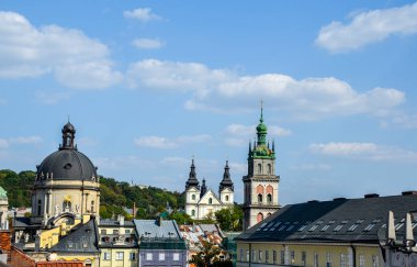 Panoramik manzara, Lviv 'in kendine özgü çatıları ve parlak, bulutlu gökyüzü altında bir dizi büyük kilisesi olan tarihi şehir manzarası. Ukrayna