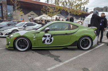 Özel yeşil Toyota GT86 coupe popüler spor araba. Düşük süspansiyon ve aerodinamik yan etekler performans odaklı değişiklikleri vurgular