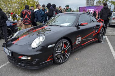 Son derece özelleştirilmiş agresif Porsche 911, 69 grafik de dahil olmak üzere koyu kırmızı yarış çizgileri ve aksanlarıyla çarpıcı bir mat siyahı içeriyor.