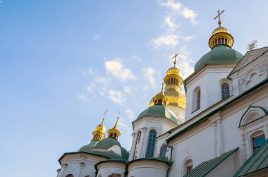 St. Sophia Katedrali 'nin yeşil ve altın kubbelerinin parlak mavi gökyüzünün altında dağınık bulutların altında görüntüsü. Kyiv, Ukrayna