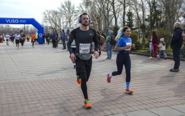 Sporcular, bir spor müsabakasında takım çalışması, çaba ve toplum ruhunu canlandıran sakin bir açık hava ortamı ile bir maratonda yarışıyorlar.