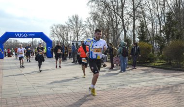 Sporcular, bir spor müsabakasında takım çalışması, çaba ve toplum ruhunu canlandıran sakin bir açık hava ortamı ile bir maratonda yarışıyorlar.