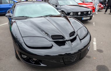 Siyah dördüncü nesil Pontiac Firebird Trans Am. Ani farları ve Ram Air kaputu kepçeleriyle agresif ön fasyası ile tanımlanabilir.