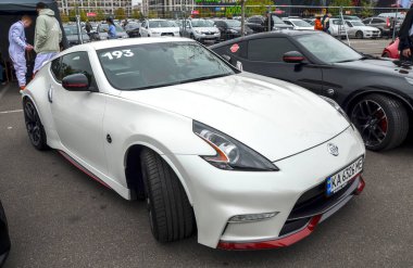 White Nissan 370Z coupe, güçlü V6 motoru ve klasik oranlarıyla bilinen modern bir spor otomobildir.