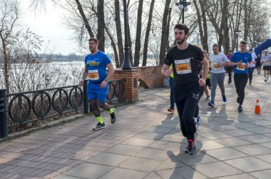 Bir maraton etkinliği sırasında ağaçların oluşturduğu patikada koşan katılımcılar, fitness ve toplumu destekliyor
