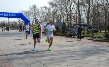 Açık hava maratonuna katılan iki kararlı koşucu, güneşli havada spor ve rekabet ruhunu sergiliyorlar.
