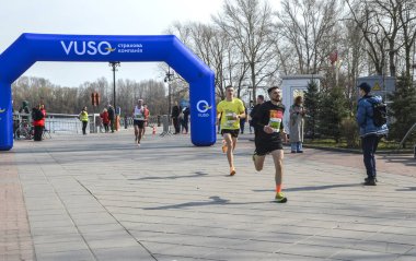Açık hava maratonuna katılan iki kararlı koşucu, güneşli havada spor ve rekabet ruhunu sergiliyorlar.