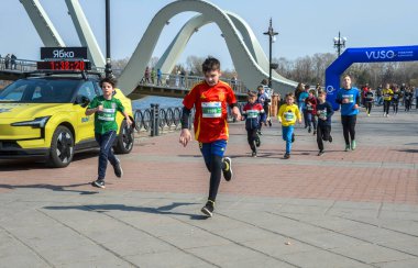 Canlı açık hava yarışına katılan enerjik çocuklar, rekabetçi ve neşeli etkinliklerden keyif alıyorlar, neşeli ortamda sağlık, aktivite ve takım çalışmasını destekliyorlar.