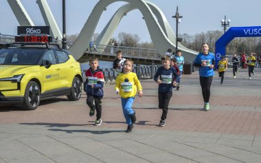 Canlı açık hava yarışına katılan enerjik çocuklar, rekabetçi ve neşeli etkinliklerden keyif alıyorlar, neşeli ortamda sağlık, aktivite ve takım çalışmasını destekliyorlar.