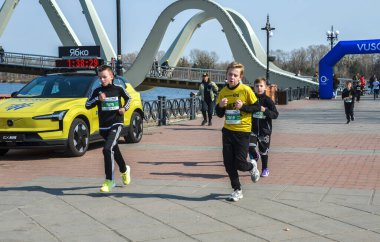 Canlı açık hava yarışına katılan enerjik çocuklar, rekabetçi ve neşeli etkinliklerden keyif alıyorlar, neşeli ortamda sağlık, aktivite ve takım çalışmasını destekliyorlar.