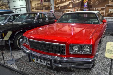 Parlak kırmızı 1975 Chevrolet Impala Chevrolet 'nin son gerçek boy ragtop' ları arasında üstü açılabilen ve büyük boyutlarıyla tanımlanabilen beşinci nesil modeldi.