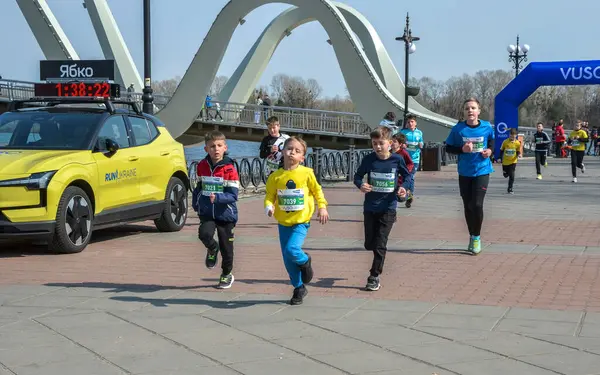 Canlı açık hava yarışına katılan enerjik çocuklar, rekabetçi ve neşeli etkinliklerden keyif alıyorlar, neşeli ortamda sağlık, aktivite ve takım çalışmasını destekliyorlar.