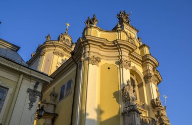 Aziz Georges Katedrali 'nin ön cephesi, süslü heykeller ve derin mavi gökyüzü ile çelişen sıcak güneş ışığıyla aydınlatılmış kubbelerle süslenmiştir. Barok-rokoko mimarisinin başyapıtı. Lviv, Ukrayna