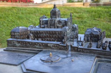 Aziz George Katedrali 'nin minyatür bronz maketi taş bir zeminde bulunur. Açık havada, arka planda yeşil çimenler ve yapraklar var. Lviv, Ukrayna