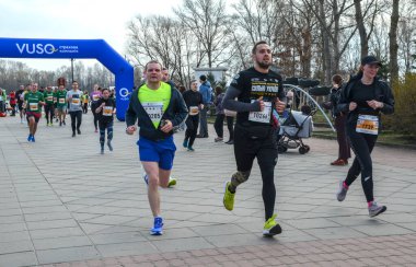 Asfalt yolda koşan katılımcıların katılacağı açık hava maratonu yarışını izleyenler izleyecek. Sahne, bahar aylarında enerjik atmosferi gösteriyor.