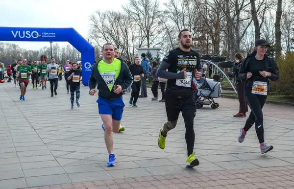 Asfalt yolda koşan katılımcıların katılacağı açık hava maratonu yarışını izleyenler izleyecek. Sahne, bahar aylarında enerjik atmosferi gösteriyor.